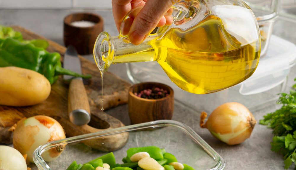 Šaukštas alyvuogių aliejaus ant medinio stalo ryto šviesoje, simbolizuojantis sveiką gyvenimo būdą.